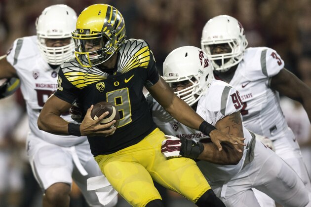 Washington State defensive tackle Xavier Cooper (96) tackles Oregon quarterback Marcus Mariota (8) and forces a fumble during the first quarter of an NCAA college football game Saturday, Sept. 20, 2014, at Martin Stadium in Pullman, Wash. (AP Photo/Dean Hare)