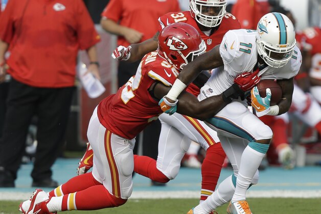 Kansas City Chiefs inside linebacker James-Michael Johnson (52) grabs Miami Dolphins wide receiver Mike Wallace (11) during the first half of an NFL football game, Sunday, Sept. 21, 2014, in Miami Gardens, Fla. (AP Photo/Wilfredo Lee)