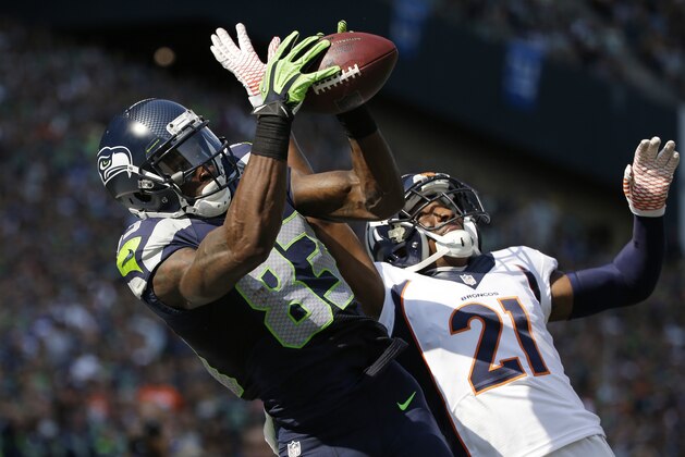 Seattle Seahawks' Ricardo Lockette (83) catches a touchdown pass in the end zone as Denver Broncos' Aqib Talib defends in the first half of an NFL football game Sunday, Sept. 21, 2014, in Seattle. (AP Photo/Elaine Thompson)