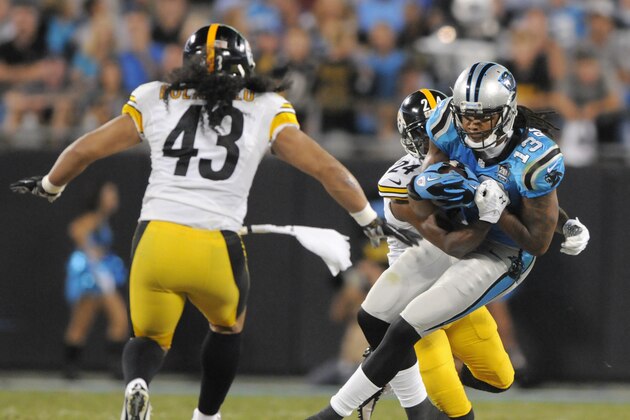 Carolina Panthers' Kelvin Benjamin (13) runs as Pittsburgh Steelers' Ike Taylor (24) wraps him up and Troy Polamalu (43) closes in during the first half of an NFL football game in Charlotte, N.C., Sunday, Sept. 21, 2014. (AP Photo/Mike McCarn)