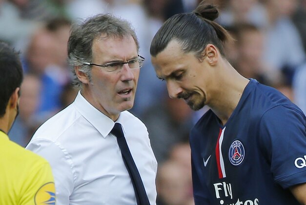 Paris Saint Germain's coach Laurent Blanc, left, talks to Swedish Zlatan Ibrahimovic, right, after being substituted, due to an injury, during a French League One soccer Match, Paris Saint Germain against Bastia, at Parc des Princes stadium, in Paris, Saturday, Aug. 16. 2014. Paris Saint Germain won 2-0. (AP Photo/Michel Euler)