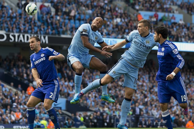 Manchester City's Edin Dzeko, second right and Vincent Kompany, centre left, jump for a ball as Chelsea's Branislav Ivanovic, left, and Diego Costa look on during their English Premier League soccer match at the Etihad Stadium, Manchester, England, Sunday Sept. 21, 2014. (AP Photo/Jon Super)