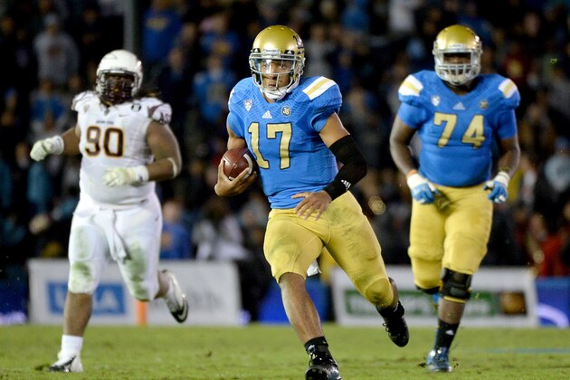 PASADENA, CA - NOVEMBER 23:  Brett Hundley #17 of the UCLA Bruins carries the ball for a first down in front of Will Sutton #90 of the Arizona State Sun Devils and teammate Caleb Benenoch #74 during the fourth quarter at Rose Bowl on November 23, 2013 in Pasadena, California.  (Photo by Harry How/Getty Images)