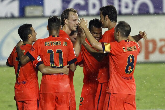 Barcelona's Ivan Rakitic, center, is congratulated by teammates after scoring a goal against Levante during a Spanish La Liga soccer match at the Ciutat de Valencia stadium in Valencia, Spain, on Sunday, Sept. 21, 2014.(AP Photo/Alberto Saiz)