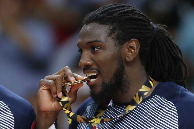 United States' Kenneth Faried bites his gold medal as he celebrates after wining the final World Basketball match against Serbia at the Palacio de los Deportes stadium in Madrid, Spain, Sunday, Sept. 14, 2014. (AP Photo/Daniel Ochoa de Olza)