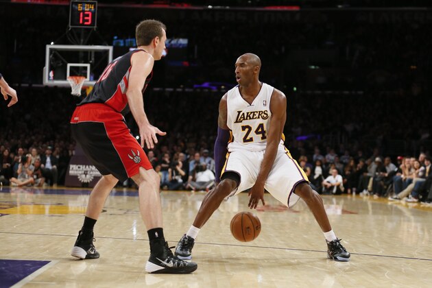 Los Angeles Lakers' Kobe Bryant dribbles the ball between his legs as Toronto Raptors' Steve Novak, left, defends during the first half of an NBA basketball game in Los Angeles, Sunday, Dec. 8, 2013. (AP Photo/Danny Moloshok)