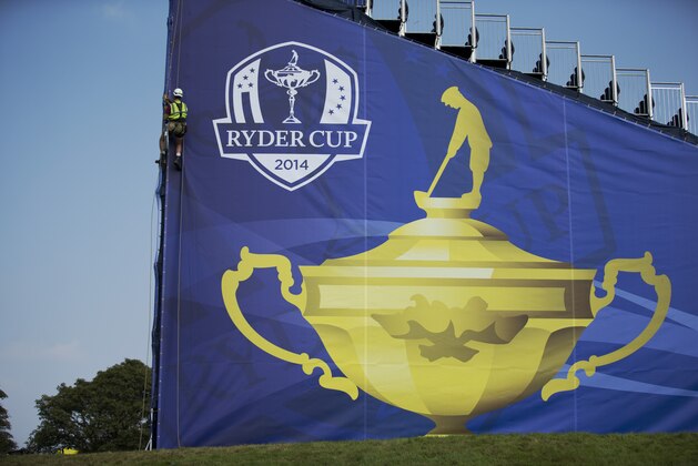 An abseiler works on hanging a drape with a Ryder Cup logo on the side of a spectator grandstand in preparation for the start of the Ryder Cup golf tournament in Gleneagles, Scotland, Sunday, Sept. 21, 2014.  The U.S. team arrives for the Ryder Cup Monday, with the tournament  starting on Friday.  (AP Photo/Matt Dunham)