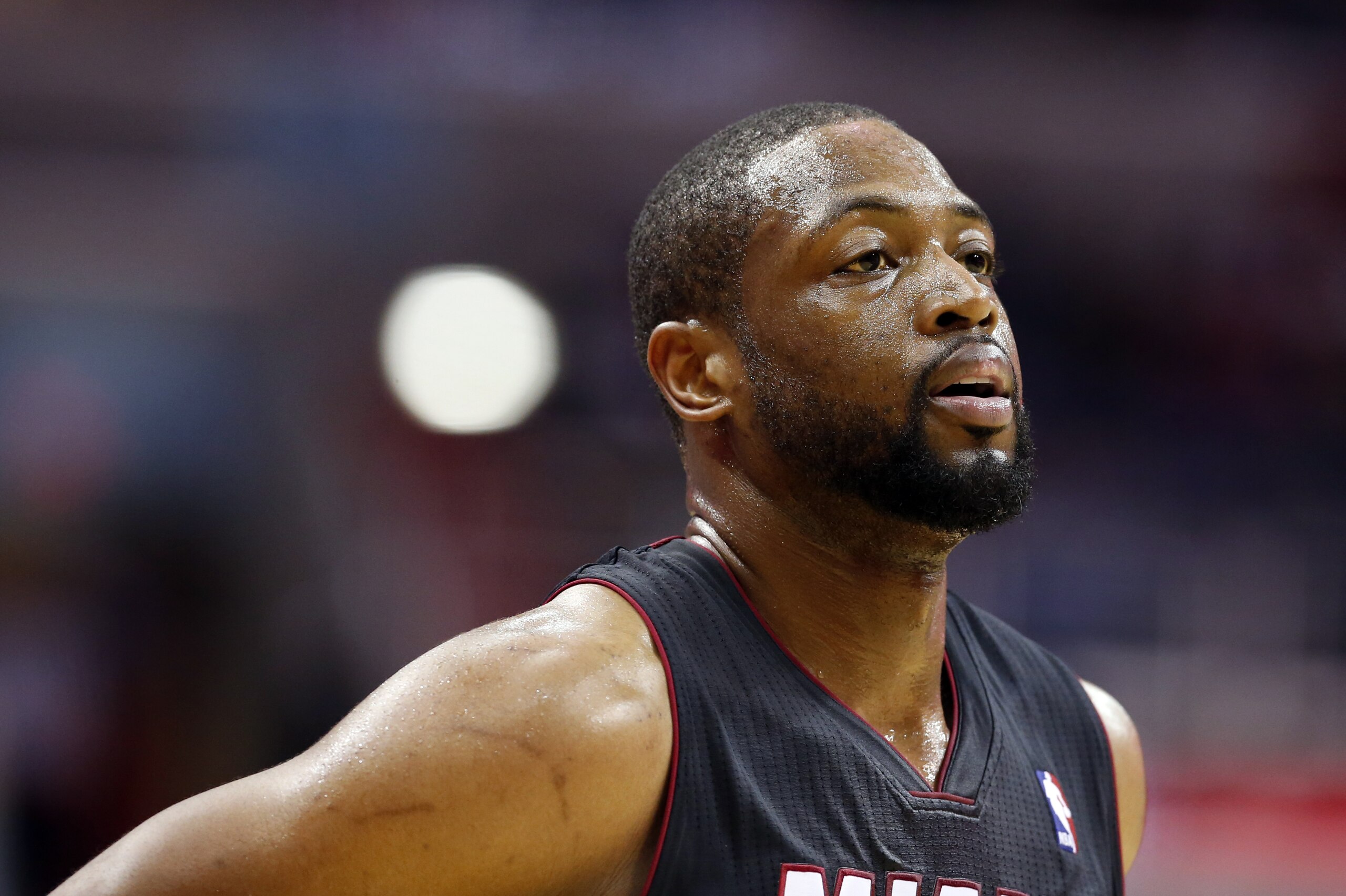 Miami Heat guard Dwyane Wade (3) pauses on the court in the first half of an NBA basketball game against the Washington Wizards, Monday, April 14, 2014, in Washington. (AP Photo/Alex Brandon)