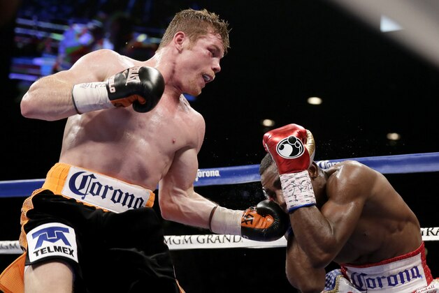 Canelo Alvarez, left, of Mexico, hits Erislandy Lara, of Cuba, during their super welterweight fight, Saturday, July 12, 2014, in Las Vegas. (AP Photo/John Locher)