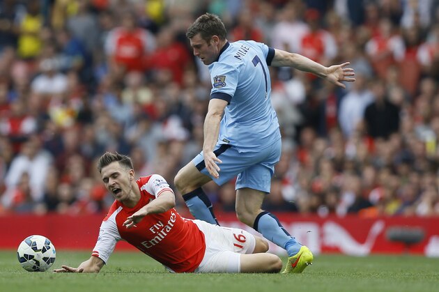 Arsenal's Aaron Ramsey, left, challenges for the ball with Manchester City's James Milner during the English Premier League soccer match between Arsenal and Manchester City at Emirates Stadium in London, Saturday, Sept. 13, 2014. (AP Photo/Kirsty Wigglesworth)