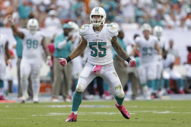 Miami Dolphins outside linebacker Koa Misi celebrates a quarterback sack during the first half of an NFL football game against the Baltimore Ravens, Sunday, Oct. 6, 2013, in Miami Gardens, Fla. Misi is wearing pink for breast cancer awareness. (AP Photo/Wilfredo Lee)