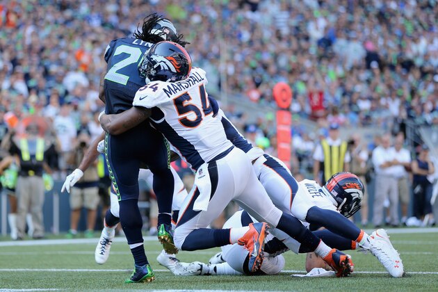 SEATTLE, WA - SEPTEMBER 21:  Running back Marshawn Lynch #24 of the Seattle Seahawks is brought down by outside linebacker Brandon Marshall #54 of the Denver Broncos for a safety in the fourth quarter at CenturyLink Field on September 21, 2014 in Seattle, Washington. The Seahawks defeated the Broncos 26-20.  (Photo by Jeff Gross/Getty Images)