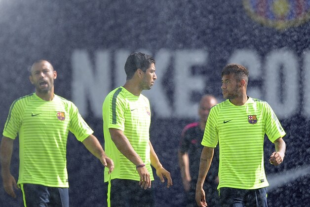 FC Barcelona's Neymar, right, talks with Luis Suarez, center, during a training session at the Sports Center FC Barcelona Joan Gamper in San Joan Despi, Spain, Tuesday, Sept. 16, 2014. FC Barcelona will play against Apoel in a group F Champions League on Wednesday Sept. 17. (AP Photo/Manu Fernandez)