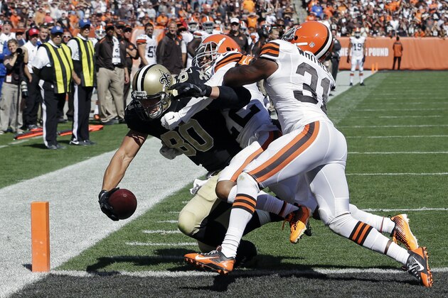 New Orleans Saints tight end Jimmy Graham (80) scores on a 1-yard touchdown pass against Cleveland Browns cornerback Buster Skrine (22) and strong safety Donte Whitner (31) in the third quarter of an NFL football game Sunday, Sept. 14, 2014, in Cleveland. (AP Photo/Tony Dejak)