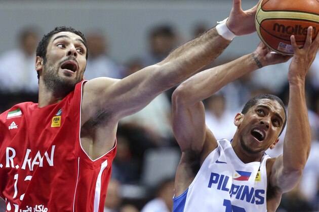 Iran's Asgher Kardoust, left, attempts to block a driving Gabriel Daniel Norwood of the Philippines in the finals of the FIBA Asia Basketball Championship at the Mall of Asia Arena at suburban Pasay city, south of Manila, Philippines Sunday Aug. 11, 2013. (AP Photo/Bullit Marquez)