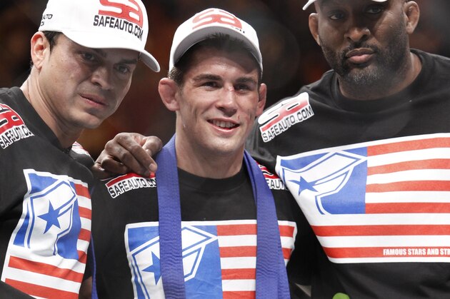 Dominick Cruz, center, poses with the belt after his victory over Urijah Faber in their UFC bantamweight mixed martial arts title match, Saturday, July 2, 2011 at The MGM Grand Garden Arena in Las Vegas. Cruz won by unanimous decision. (AP Photo/Eric Jamison)
