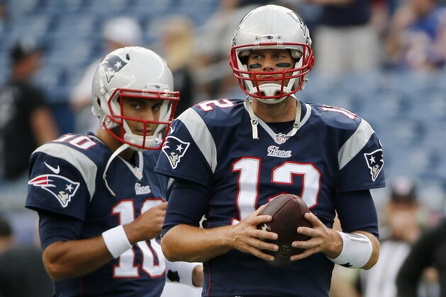 New England Patriots quarterbacks Jimmy Garoppolo (10) and Tom Brady (12) pause during warm-up's before an NFL football game Sunday, Sept. 21, 2014, in Foxborough, Mass. (AP Photo/Elise Amendola)