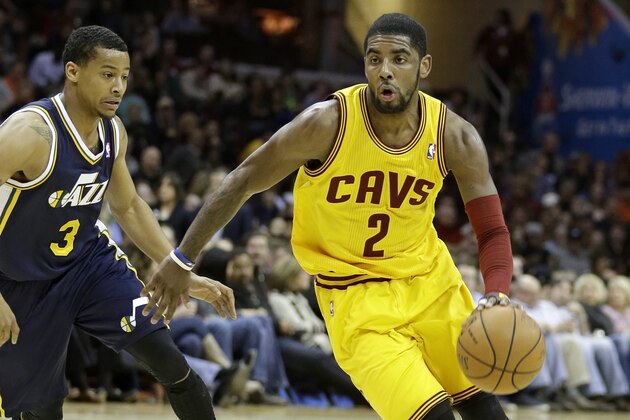 Cleveland Cavaliers' Kyrie Irving (2) drives past Utah Jazz's Trey Burke (3) during an NBA basketball game Friday, Feb. 28, 2014, in Cleveland. (AP Photo/Tony Dejak)