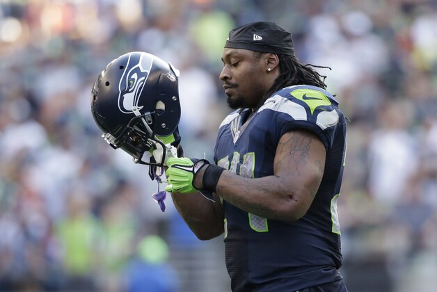 Seattle Seahawks running back Marshawn Lynch (24) puts on his helmet during the second half of an NFL football game against the Denver Broncos, Sunday, Sept. 21, 2014, in Seattle. (AP Photo/Elaine Thompson)
