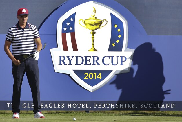 Rickie Fowler of the US waits to play off the 17th tee as the shadows of Phil Mickelson of the US and his caddie Jim Mackay are cast onto the boarding during a practice round ahead of the Ryder Cup golf tournament at Gleneagles, Scotland, Wednesday, Sept. 24, 2014. (AP Photo/Scott Heppell)