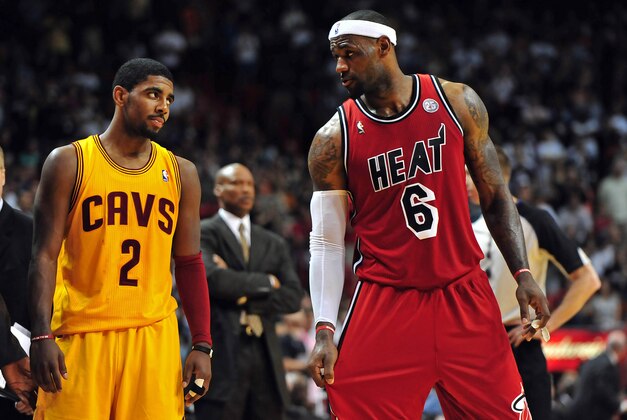 Feb 24, 2013; Miami, FL, USA; Cleveland Cavaliers point guard Kyrie Irving (left) looks over at Miami Heat small forward LeBron James (right) as Cleveland Cavaliers head coach Byron Scott (center) looks on during the second half at the American Airlines Arena.  MIami won 109-105. Mandatory Credit: Steve Mitchell-USA TODAY Sports