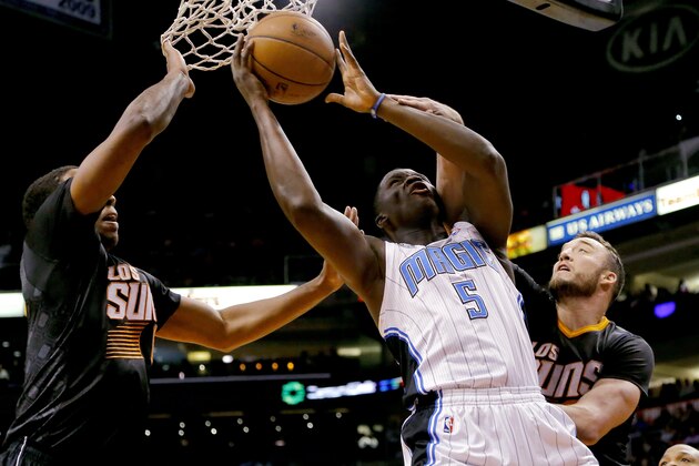 Orlando Magic guard Victor Oladipo (5) shoots betweeb Phoenix Suns center Miles Plumlee, right, and guard Eric Bledsoe during the first half of an NBA basketball game, Wednesday, March 19, 2014, in Phoenix. (AP Photo/Matt York)