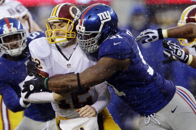 FILE - In this Dec. 29, 2013, file photo, New York Giants defensive end Justin Tuck, right, sacks Washington Redskins' Kirk Cousins (12) during the first half of an NFL football game in East Rutherford, N.J. Tuck signed with the Oakland Raiders. (AP Photo/Julio Cortez, File)