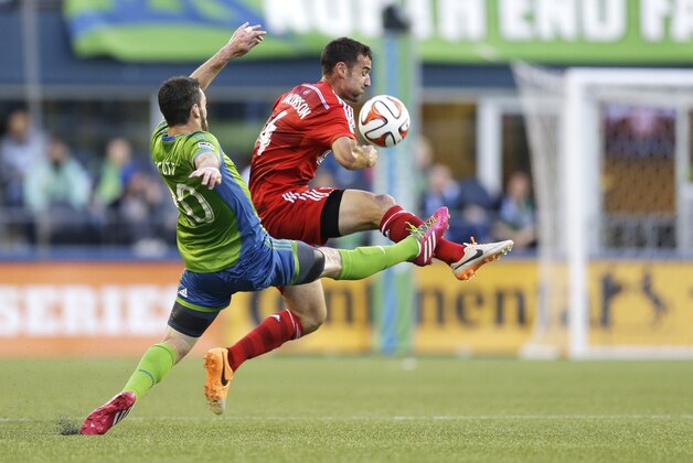 Seattle Sounders' Zach Scott, left, battles with FC Dallas' Andrew Jacobson, right, for the ball, Wednesday, May 7, 2014, in the first half of an MLS soccer match in Seattle. The Sounders defeated FC Dallas, 2-1. (AP Photo/Ted S. Warren)