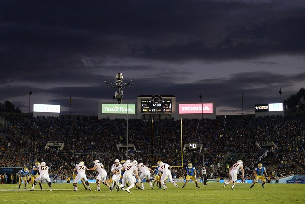 PASADENA, CA - NOVEMBER 23:  Taylor Kelly #10 of the Arizona State Sun Devils fakes a handoff to D.J. Foster #8 during the second quarter against the UCLA Bruins at Rose Bowl on November 23, 2013 in Pasadena, California.  (Photo by Harry How/Getty Images)