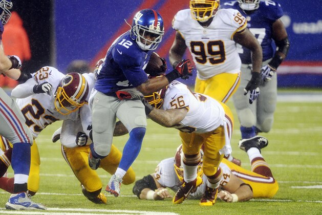 New York Giants wide receiver Jerrel Jernigan (12) runs past Washington Redskins' Perry Riley (56) and DeAngelo Hall (23) during the second half of an NFL football game on Sunday, Dec. 29, 2013, in East Rutherford, N.J. (AP Photo/Bill Kostroun)