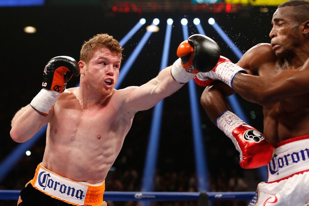 LAS VEGAS, NV - JULY 12:  (L-R) Canelo Alvarez lands a left to the head of Erislandy Lara during their junior middleweight bout at the MGM Grand Garden Arena on July 12, 2014 in Las Vegas, Nevada.  Alvarez defeated Lara by split decision.  (Photo by Josh Hedges/Getty Images)