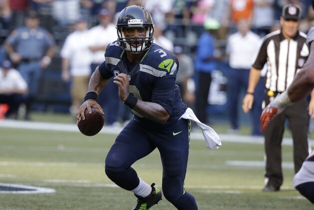Seattle Seahawks quarterback Russell Wilson looks to pass in the second half of an NFL football game against the Denver Broncos, Sunday, Sept. 21, 2014, in Seattle. (AP Photo/Elaine Thompson)