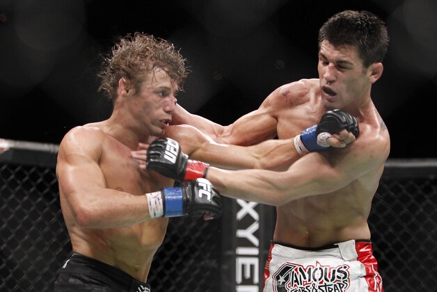 Urijah Faber, left, trades punches with Dominick Cruz during the first round of their UFC bantamweight mixed martial arts title match, Saturday, July 2, 2011 at The MGM Grand Garden Arena in Las Vegas. Cruz won by unanimous decision. (AP Photo/Eric Jamison)