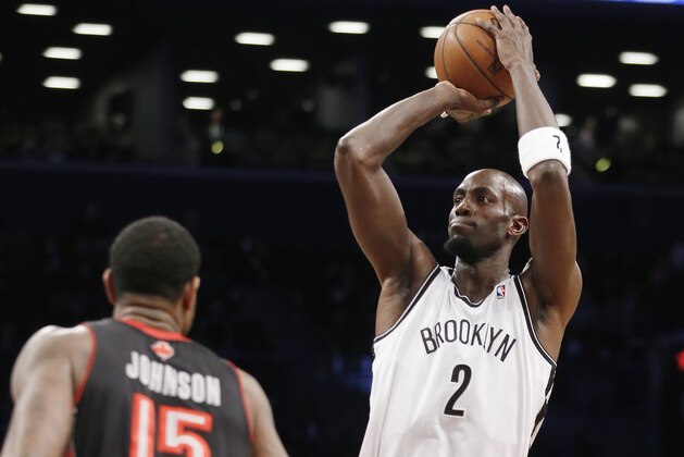 Brooklyn Nets forward Kevin Garnett (2) shoots over Toronto Raptors forward Amir Johnson (15) in the first half of their NBA basketball game at the Barclays Center, Monday, Jan. 27, 2014, in New York. (AP Photo/Kathy Willens)