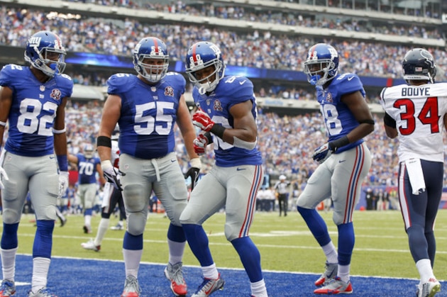 New York Giants wide receiver Victor Cruz (80), center, celebrates with wide receiver Rueben Randle (82), center J.D. Walton (55) and wide receiver Corey Washington (88) after scoring a touchdown against the Houston Texans in the second quarter of an NFL football game, Sunday, Sept. 21, 2014, in East Rutherford, N.J. (AP Photo/Kathy Willens)