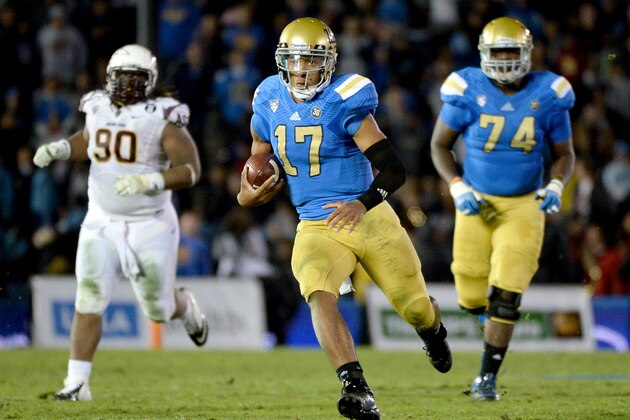 PASADENA, CA - NOVEMBER 23:  Brett Hundley #17 of the UCLA Bruins carries the ball for a first down in front of Will Sutton #90 of the Arizona State Sun Devils and teammate Caleb Benenoch #74 during the fourth quarter at Rose Bowl on November 23, 2013 in Pasadena, California.  (Photo by Harry How/Getty Images)