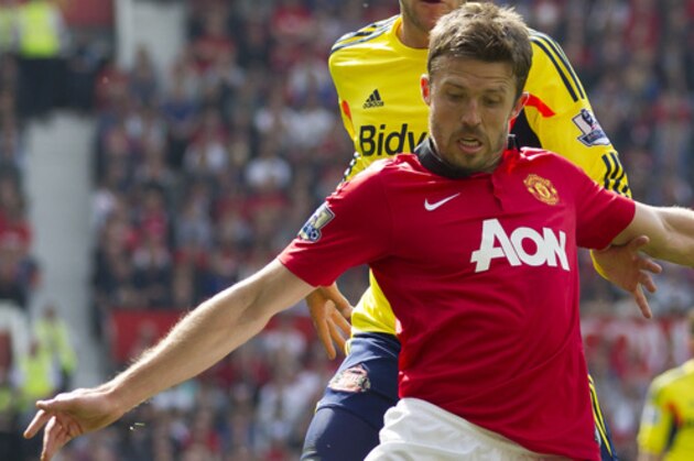 Manchester United's Michael Carrick, foreground, keeps the ball from Sunderland's Marcos Alonso during their English Premier League soccer match at Old Trafford Stadium, Manchester, England, Saturday May 3, 2014. (AP Photo/Jon Super)