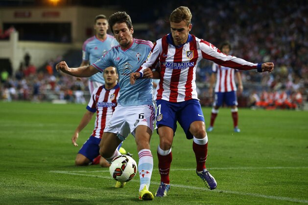 Atletico's Antoine Griezmann, right, in action with  Celta's Radoja, left, during a Spanish La Liga soccer match between Celta and Atletico Madrid at the Vicente Calderon stadium in Madrid, Spain, Saturday, Sept. 20, 2014. (AP Photo/Andres Kudacki)