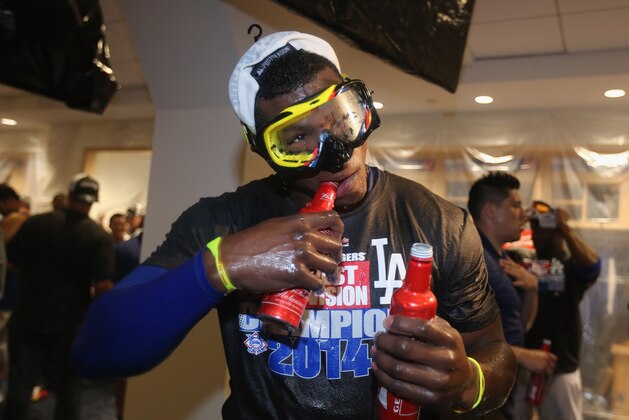 LOS ANGELES, CA - SEPTEMBER 24:  Yasiel Puig #66 of the Los Angeles Dodgers uses his teeth to open a bottle of beer in the locker room following the Dodgers' 9-1 victory over the San Francisco Giants to win the National League West Division Championship at Dodger Stadium on September 24, 2014 in Los Angeles, California.  (Photo by Jeff Gross/Getty Images)