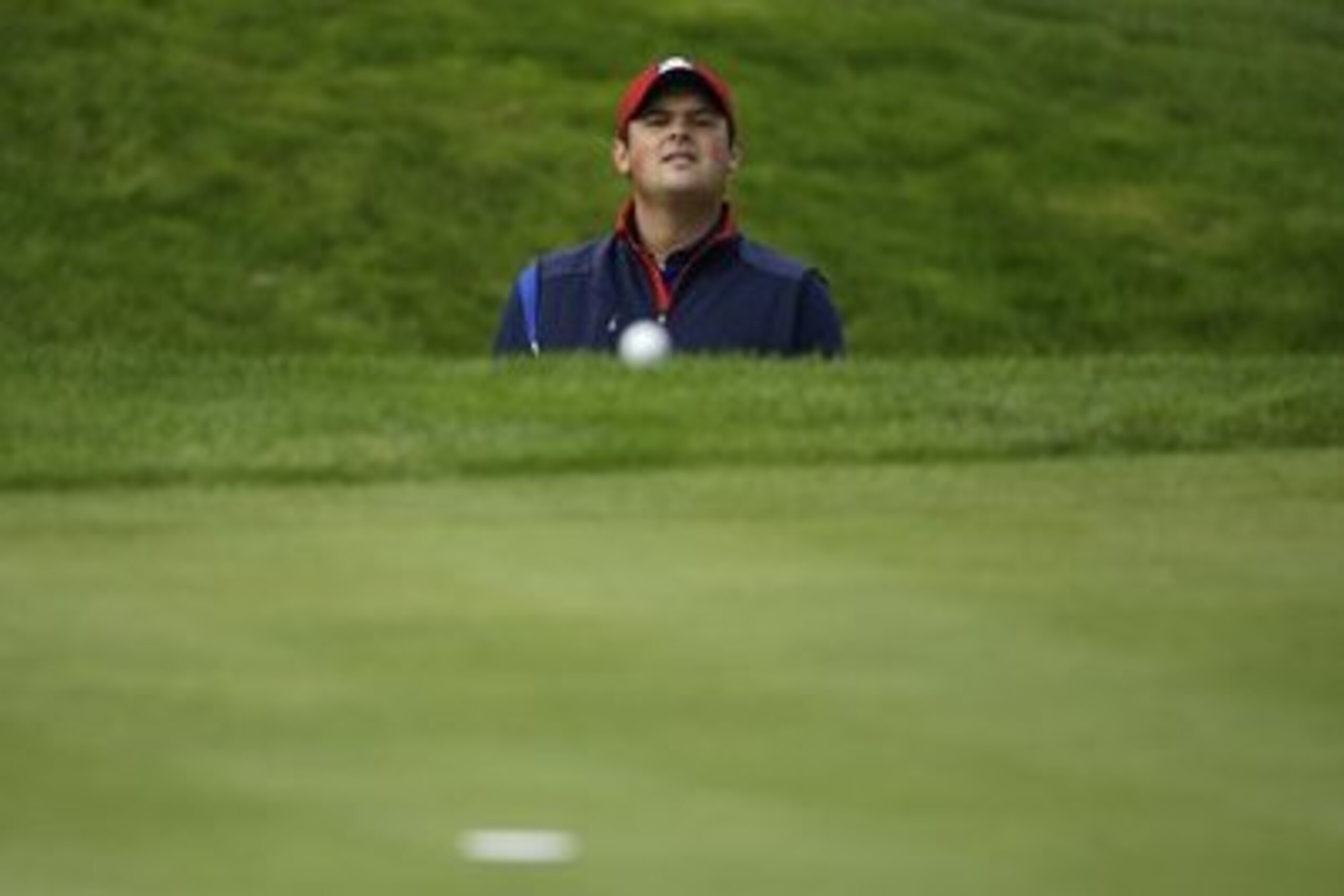 Patrick Reed of the US looks out of a bunker after playing onto the 14th green during a practice round ahead of the Ryder Cup golf tournament at Gleneagles, Scotland, Thursday, Sept. 25, 2014. (AP Photo/Matt Dunham)