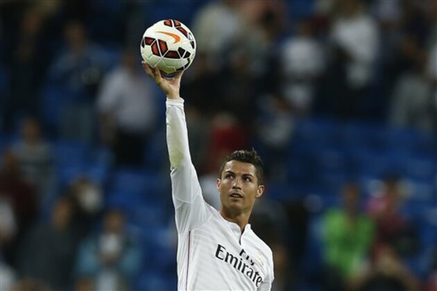 Real's Cristiano Ronaldo holds the ball as he celebrates his four goals during a Spanish La Liga soccer match between Real Madrid and Elche at the Santiago Bernabeu stadium in Madrid, Spain, Tuesday, Sept. 23, 2014. (AP Photo/Andres Kudacki)