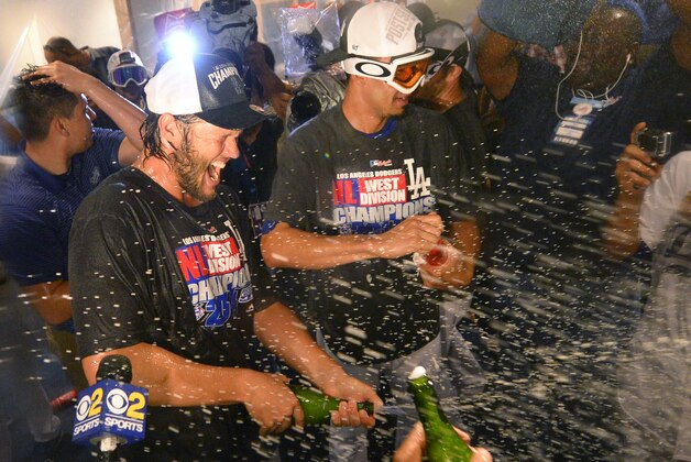 Los Angeles Dodgers' Clayton Kershaw, left, sprays champagne after they defeated the San Francisco Giants 9-1 and clinching the National League West Division title in a baseball game, Wednesday, Sept. 24, 2014, in Los Angeles. (AP Photo/Mark J. Terrill)