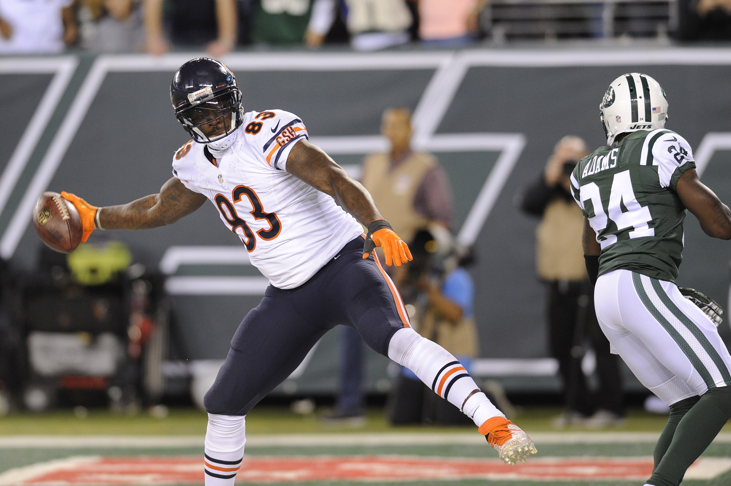 Chicago Bears tight end Martellus Bennett (83) spikes the ball after catching a touchdown pass against New York Jets defensive back Phillip Adams (24) in the third quarter of an NFL football game, Monday, Sept. 22, 2014, in East Rutherford, N.J. (AP Photo/Bill Kostroun)