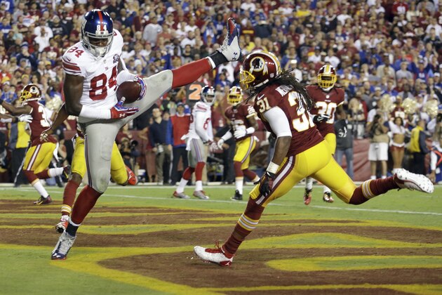 New York Giants tight end Larry Donnell (84) pulls in his second touchdown of the game, under pressure from Washington Redskins strong safety Brandon Meriweather (31) during the first half of an NFL football game in Landover, Md., Thursday, Sept. 25, 2014. (AP Photo/Patrick Semansky)