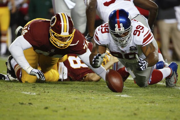 New York Giants defensive tackle Cullen Jenkins (99) falls on a loose ball as Washington Redskins tackle Tyler Polumbus (74) closes in after Redskins quarterback Kirk Cousins was sacked during the first half of an NFL football game in Landover, Md., Thursday, Sept. 25, 2014. The New York Giants recoved the fumble. (AP Photo/Alex Brandon)