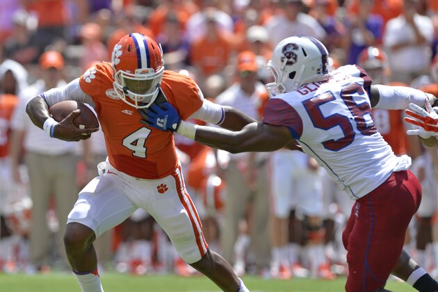 Clemson quarterback Deshaun Watson runs out of the pocket and is pressured by South Carolina State's Alexander Glover during an NCAA college football game in Clemson, S.C.,  Saturday, Sept. 6, 2014.  (AP Photo/ Richard Shiro)