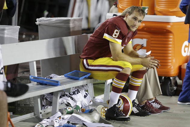 Washington Redskins quarterback Kirk Cousins sits on the bench after this third interception, during the second half of an NFL football game against the New York Giants in Landover, Md., Thursday, Sept. 25, 2014. (AP Photo/Patrick Semansky)