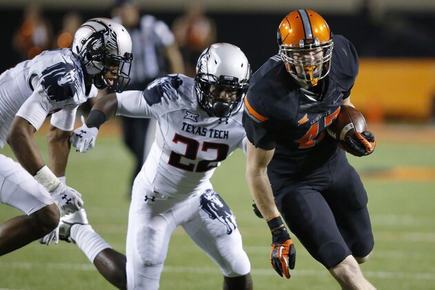 Oklahoma State tight end Blake Jarwin (47) carries a Daxx Garman pass into the end zone in front of Texas Tech safety Derrick Dixon (22) and defensive back Justis Nelson, left, in the third quarter of an NCAA college football game in Stillwater, Okla., Thursday, Sept. 25, 2014. Oklahoma State won 45-35. (AP Photo/Sue Ogrocki)