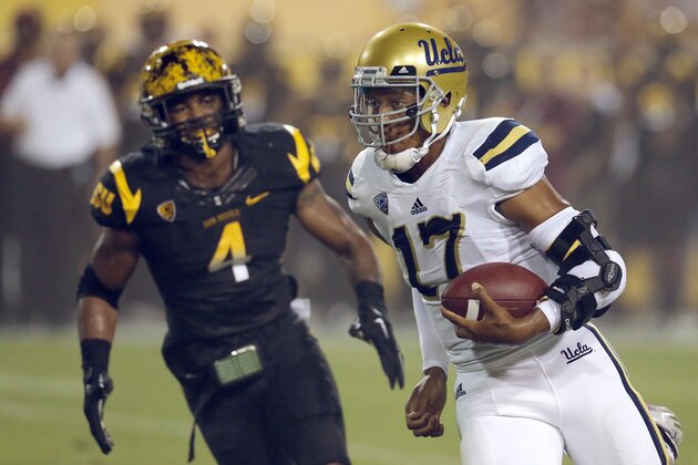 UCLA quarterback Brett Hundley (17) scrambles as Arizona State linebacker Dj Calhoun (4) pursues during the first half of an NCAA college football game, Thursday, Sept. 25, 2014, in Tempe, Ariz. (AP Photo/Rick Scuteri)