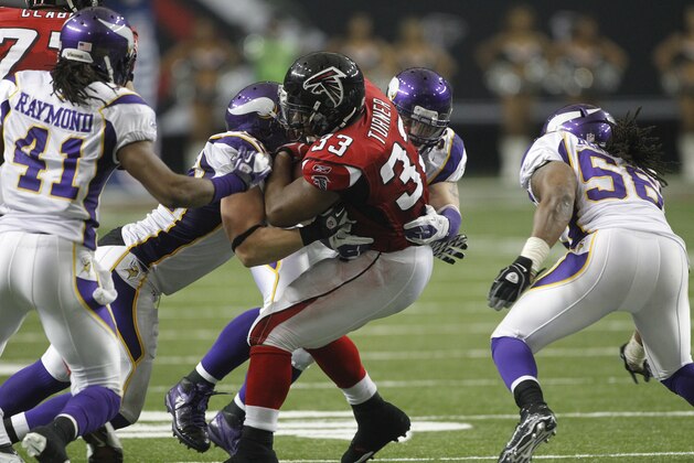Atlanta Falcons running back Michael Turner (33) is hit by Minnesota Vikings defenders during the first half of an NFL football game Sunday, Nov. 27, 2011, in Atlanta. (AP Photo/John Bazemore)